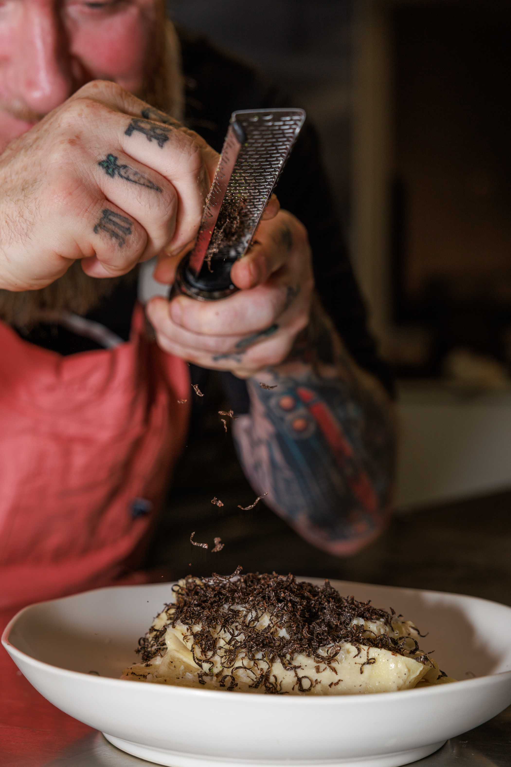 Chef grating truffles over pasta at Salty Zebra Bistro Jupiter