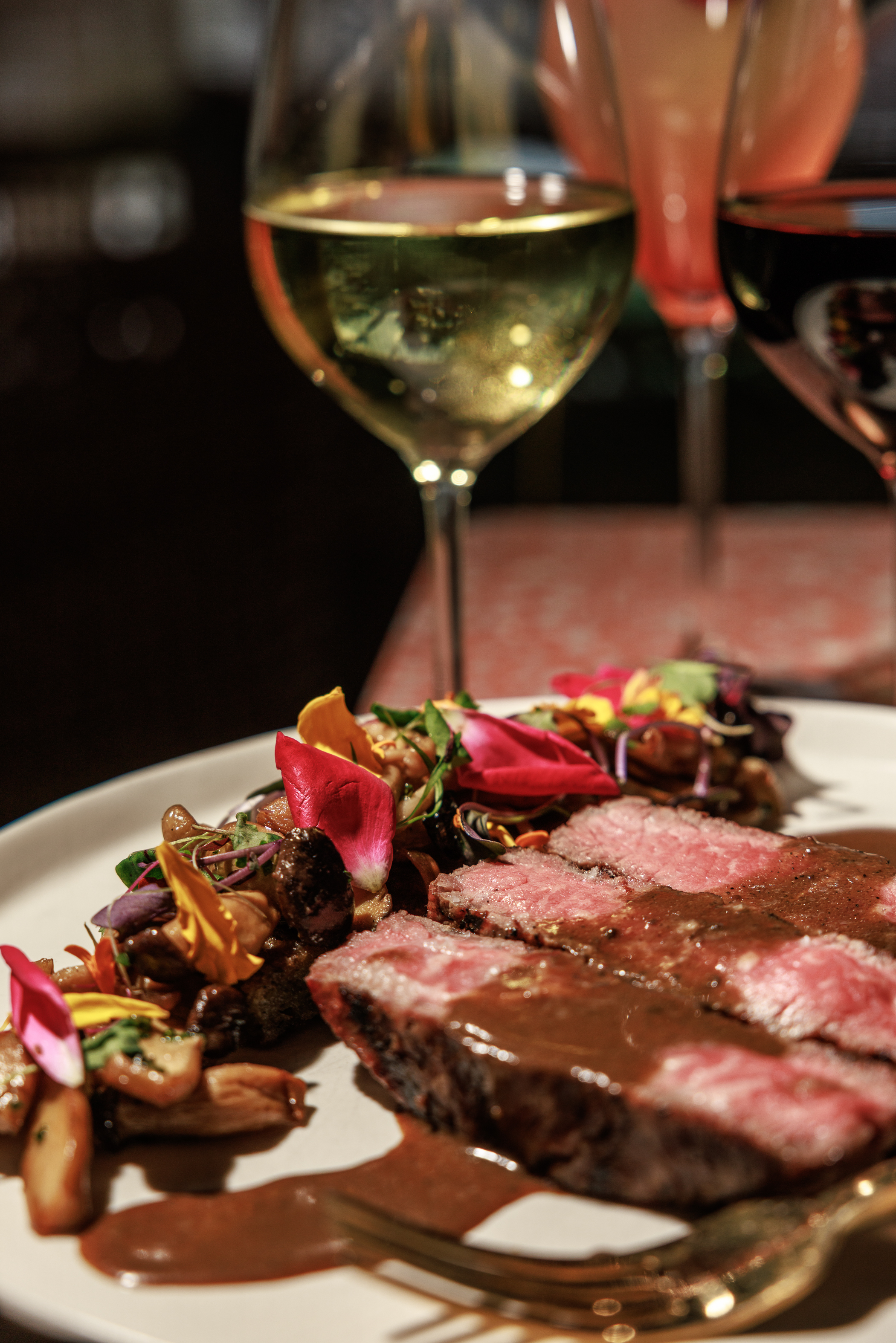 Chef Michael Luth's Era of Excess NYE 2025 menu at The Salty Zebra Bistro - prime steak with rich sauce, seasonal vegetables, and wine pairings in an elegant fine dining setting